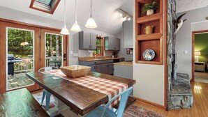 A modern kitchen with a central island, wooden shelves, and a view of the outdoors. - Front Porch Therapy - Escape to your hideaway only 6 minutes above Boone (Boone)