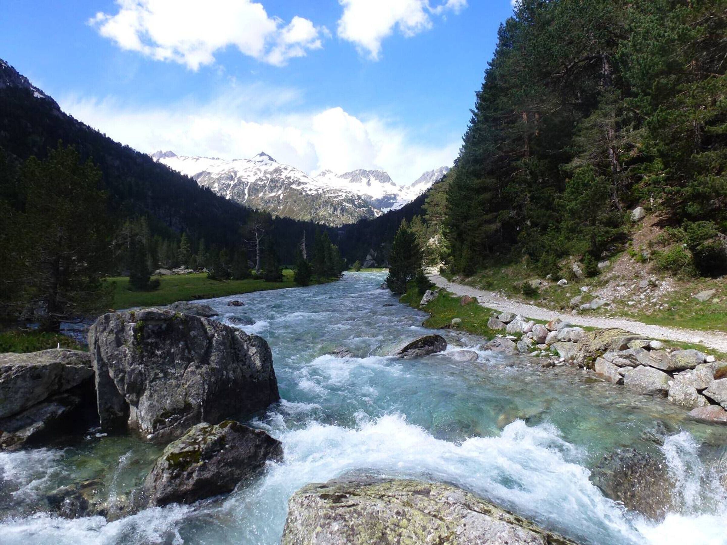 A river flowing through a mountainous landscape with a clear sky.