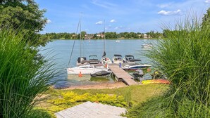 A marina with boats docked, a dock, and a grassy area with shrubs. - 2 bedroom beautiful apartment in Rydzewo (Rydzewo)