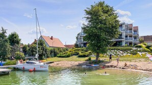 A marina with boats, a sandy beach, and modern buildings in the background. - 2 bedroom beautiful apartment in Rydzewo (Rydzewo)