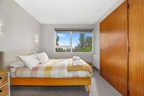 Ein Schlafzimmer mit einem Bett, einem Fenster und einem Kleiderschrank.
