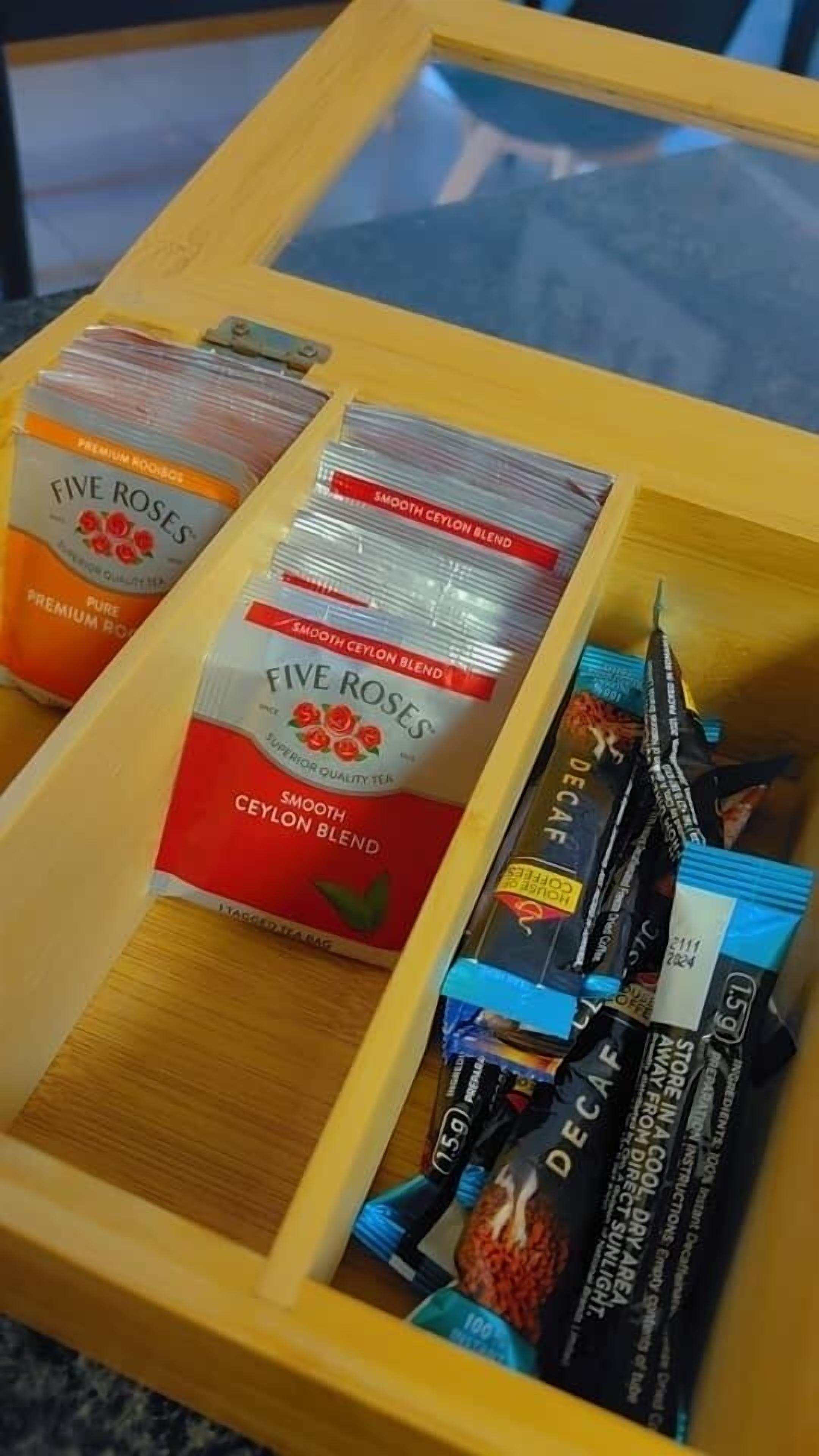 A wooden tray with tea bags and a box of Five Roses tea.