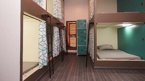 A narrow hallway with bunk beds on one side and lockers on the other. - Lost & Found Dooms (Zanzibar Town)