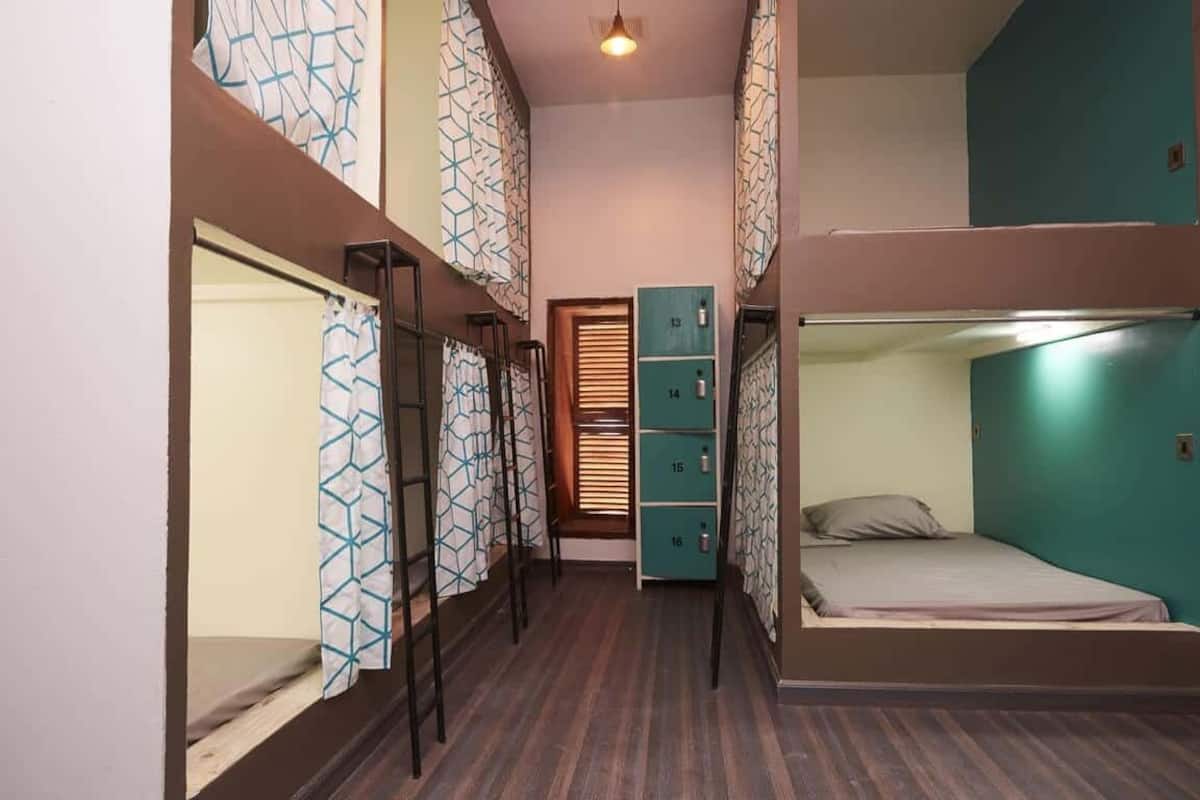 A narrow hallway with bunk beds on one side and lockers on the other.