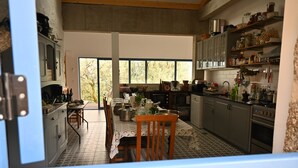 Una cocina amplia con comedor, ventanas grandes y vistas al exterior.