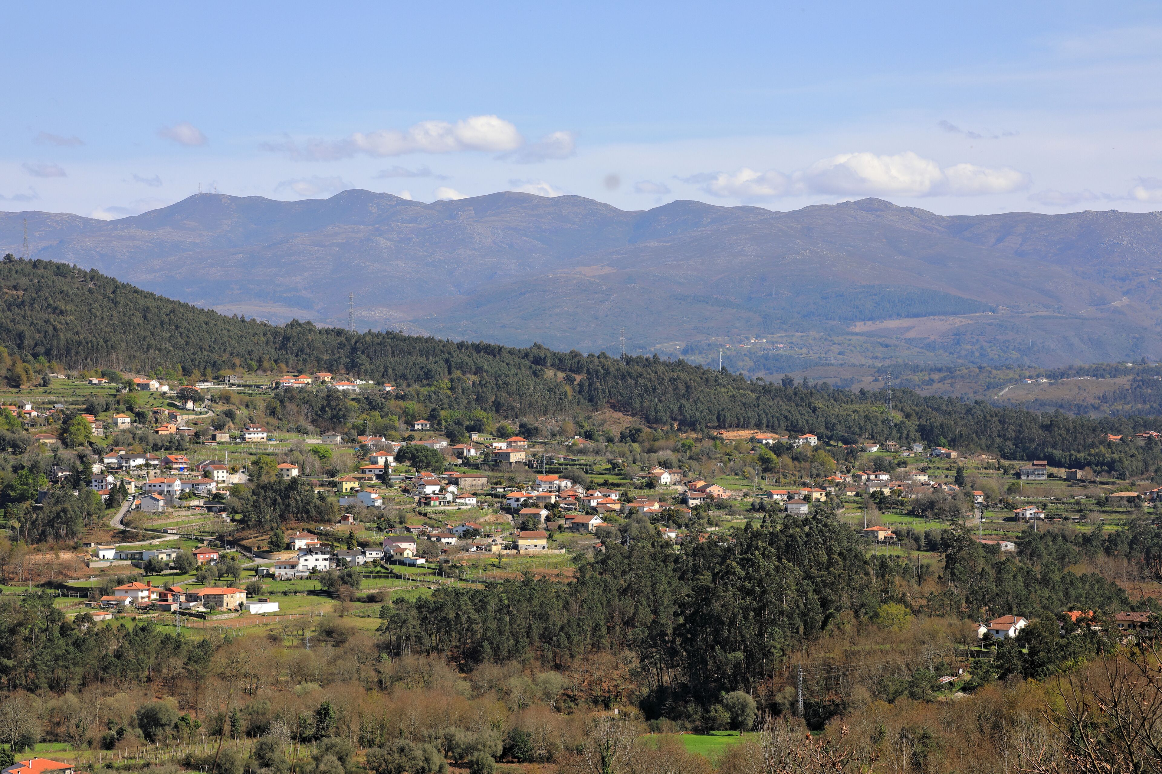 A rural village with houses spread across a hilly landscape.