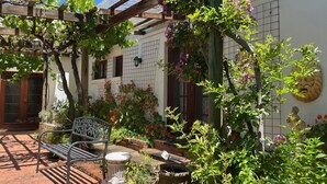 A courtyard with a pergola, a bench, and potted plants. - Private Country Retreat Taradale Valley Tumbarumba in Snowy Mtns foothills.  (Tumbarumba)