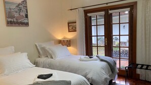 A hotel room with two beds, a nightstand, a lamp, a window with curtains, and a view of the outdoors. - Private Country Retreat Taradale Valley Tumbarumba in Snowy Mtns foothills.  (Tumbarumba)