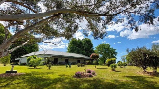A house with a lawn, trees, and a clear sky. - Private Country Retreat Taradale Valley Tumbarumba in Snowy Mtns foothills.  (Tumbarumba)