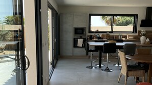 Una cocina moderna con comedor, ventanas amplias y vistas al exterior.