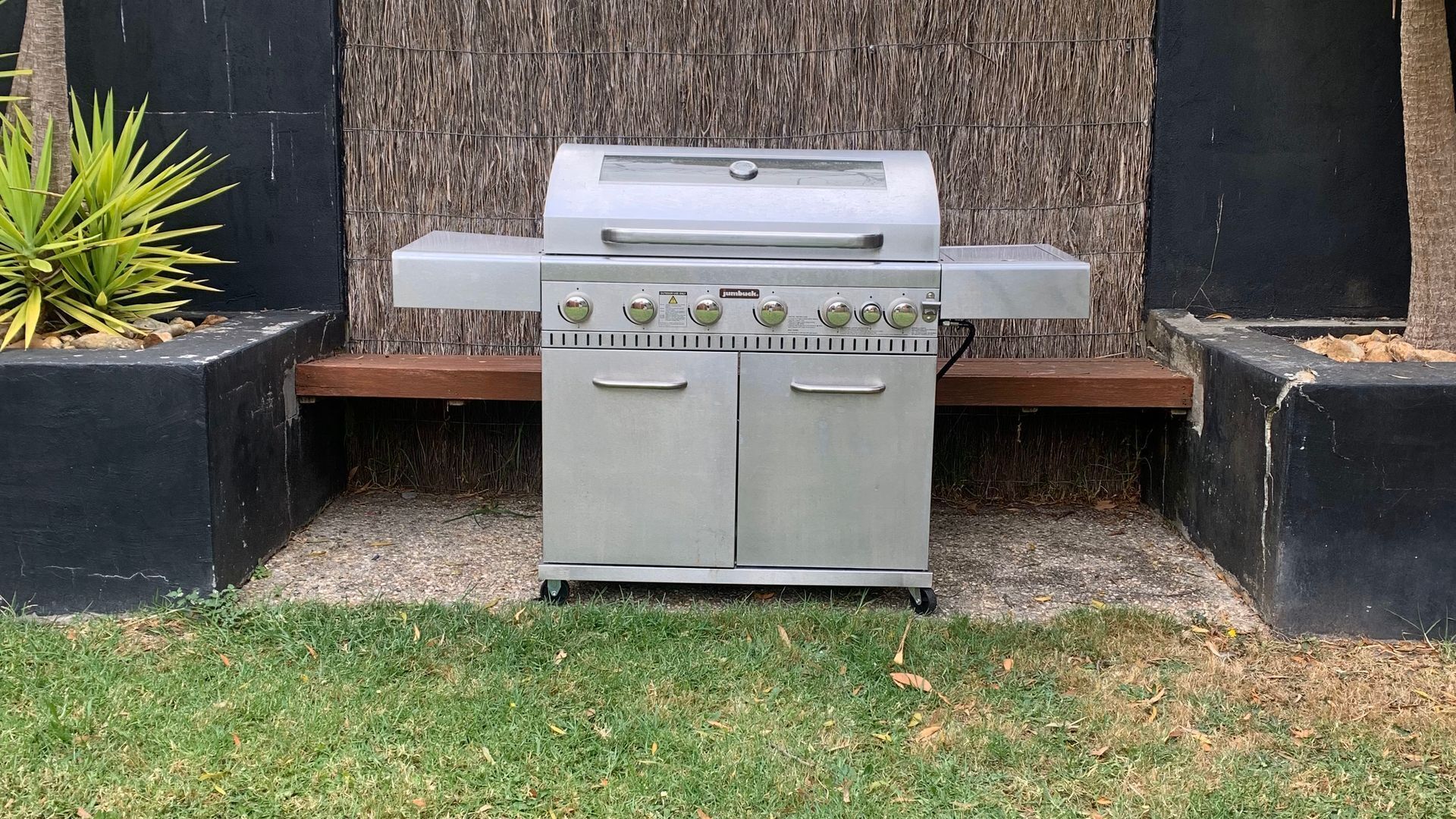 Ein tragbarer Gasgrill mit Bedienfeld, zwei Seitentüren und einer Grillfläche.