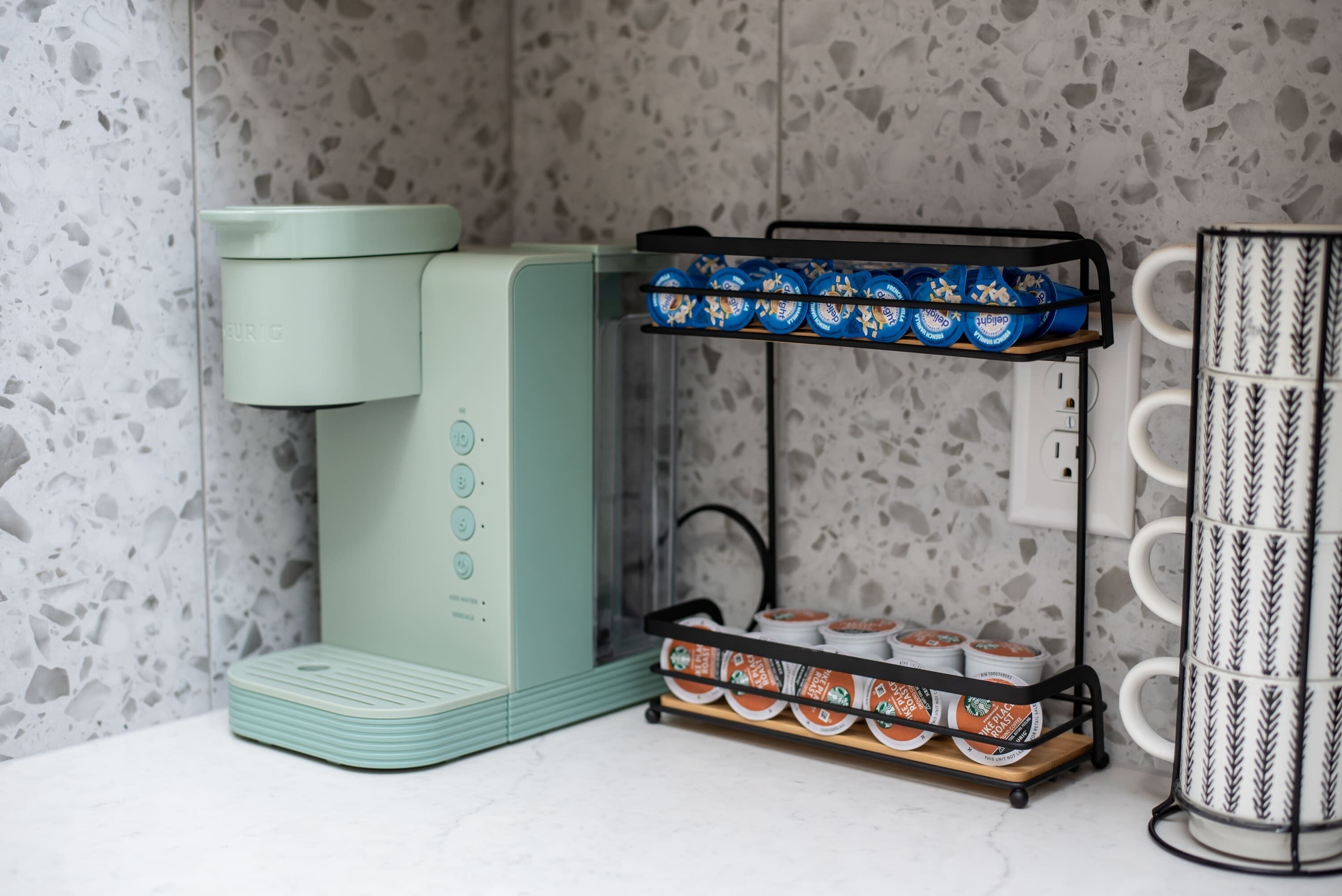 Eine Küche mit einer grünen Kaffeemaschine, einem Kaffeetassenhalter und einer Kaffeemaschine.