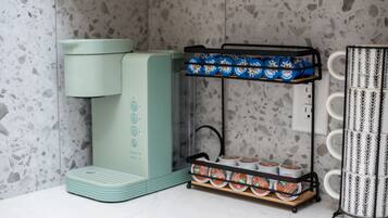 Eine Küche mit einer grünen Kaffeemaschine, einem Kaffeetassenhalter und einer Kaffeemaschine.