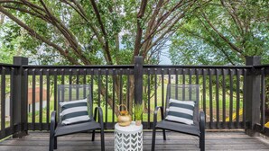 A deck with two black chairs, a white and black patterned table, and a small potted plant. - Beautiful 6 bed, 3 bath home in quiet neighborhood (Wichita)