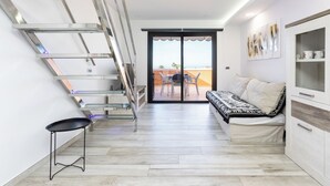 Un intérieur moderne avec un escalier, un canapé et un coin repas.
