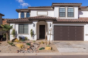 A two-story house with a garage, a front entrance, and a landscaped garden with rocks and plants. - 5 BR - Siena Hills Resort - Patio, BBQ & Games (Washington)