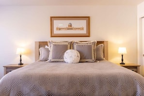 A bedroom with a large bed, two bedside lamps, a framed picture on the wall, and a patterned bedspread. - 5 BR - Siena Hills Resort - Patio, BBQ & Games (Washington)