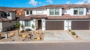 A two-story house with a tiled roof, a garage, and a landscaped front yard with small plants and rocks. - 5 BR - Siena Hills Resort - Patio, BBQ & Games (Washington)