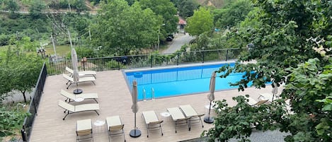 Een seizoensgebonden buitenzwembad, parasols voor strand/zwembad