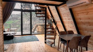 Ein modernes Interieur mit Holzboden, einer Wendeltreppe und einem Essbereich mit Stühlen.