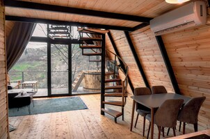Un interior moderno con suelo de madera, una escalera de caracol y un comedor con sillas.