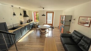 Cozinha moderna com área de refeições, um sofá e uma mesa de madeira.