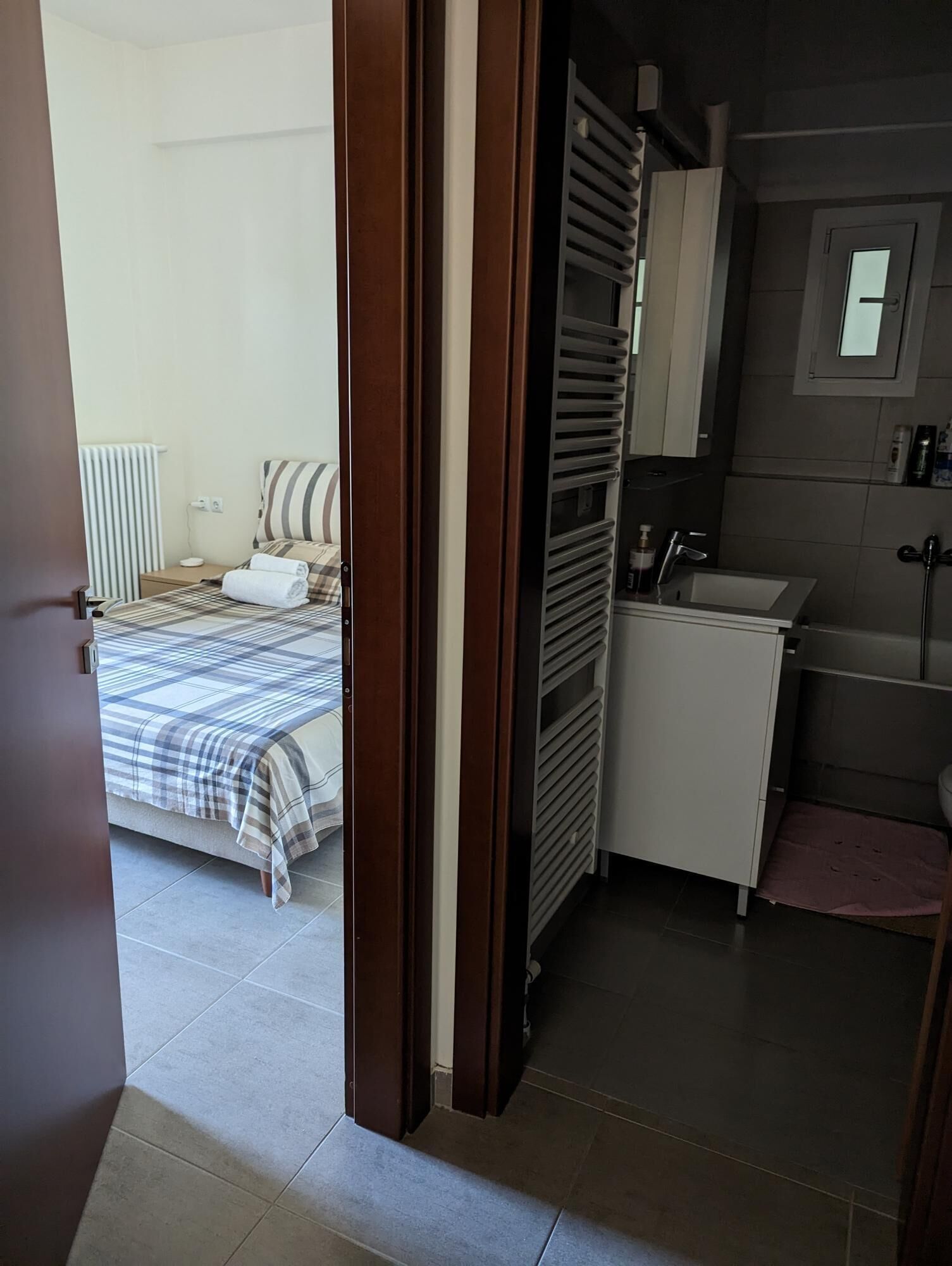 A bedroom with a bed, a bedside table, and a radiator.