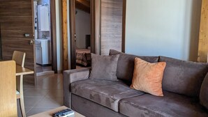 Ein modernes Wohnzimmer mit einem grauen Sofa, einem Holztisch und einer Holzzahl.