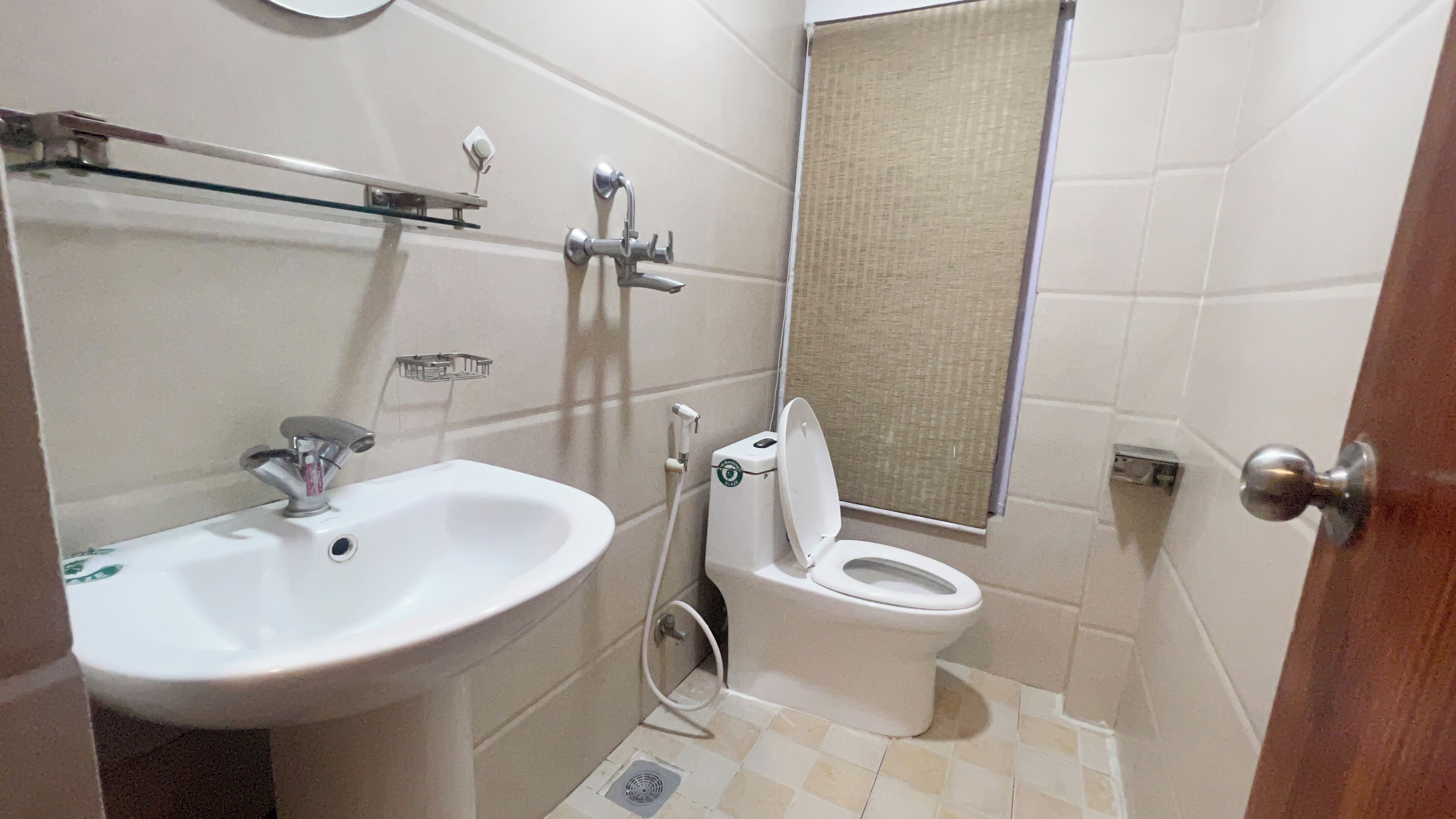 A small bathroom with a sink, toilet, and a mirror.