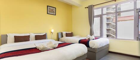 A hotel room with two beds, a window with a view of the building, and an air conditioning unit on the wall.