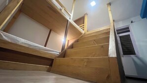 Un escalier en bois avec un lit superposé en bas.