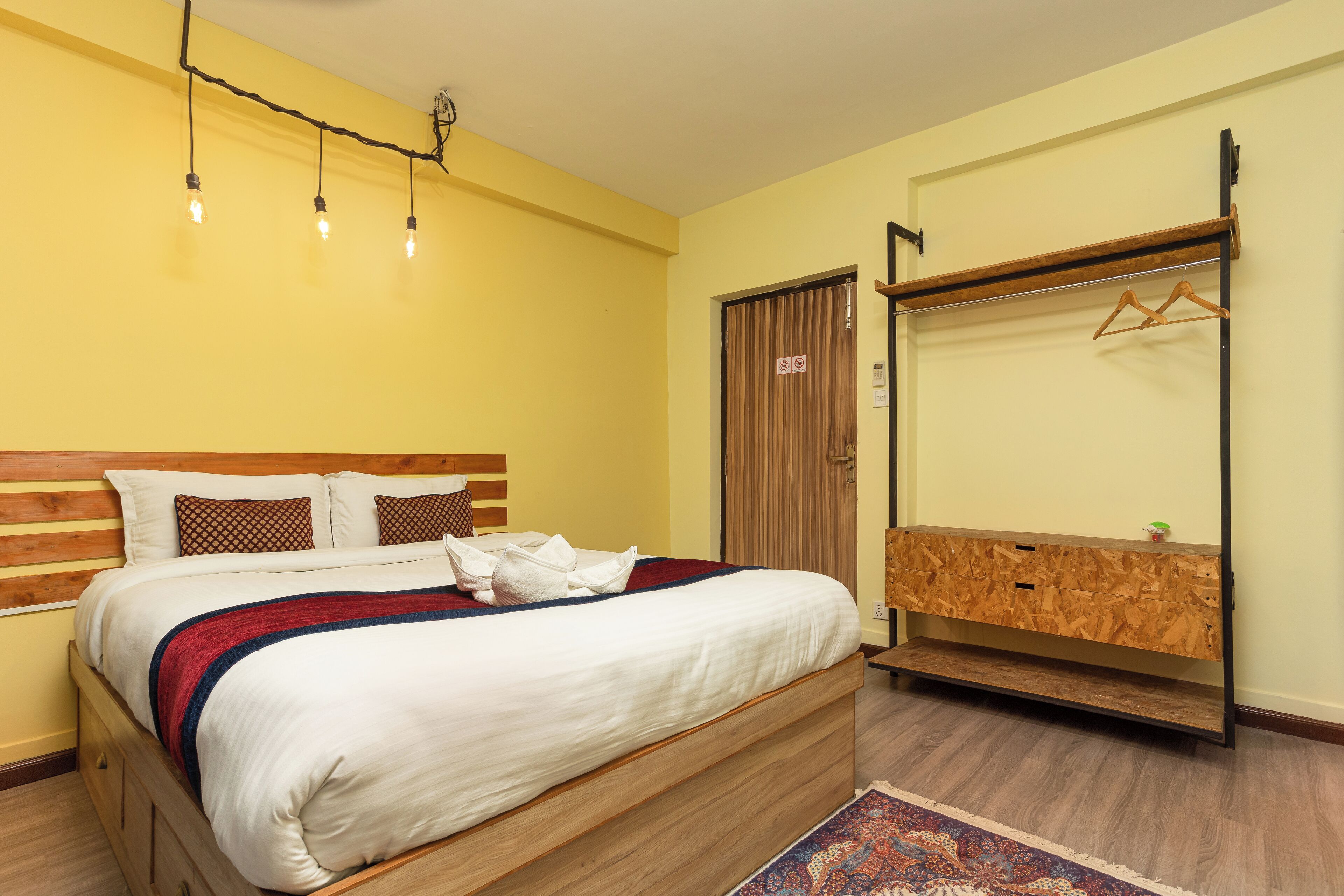 Une chambre à coucher avec un lit en bois, une armoire en bois et un miroir.