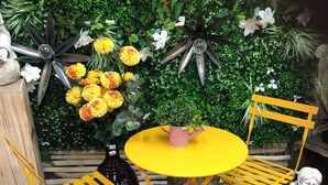 A yellow table and two yellow chairs with a small potted plant in the center.