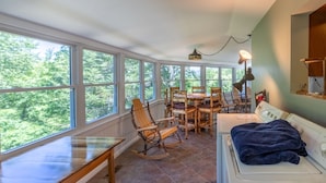 A laundry area with a washing machine, a drying rack, and a rocking chair. - Hike Inn Bryson-Game Room - Fire Pit - Private Location -Wrap Around Deck (Bryson City)