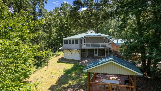 A two-story house with a balcony, surrounded by trees. - Hike Inn Bryson-Game Room - Fire Pit - Private Location -Wrap Around Deck (Bryson City)