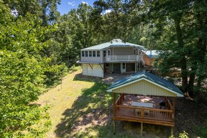 A two-story house with a balcony, surrounded by trees. - Hike Inn Bryson-Game Room - Fire Pit - Private Location -Wrap Around Deck (Bryson City)