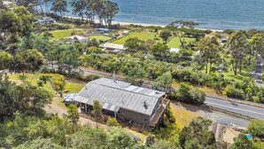 Una propiedad costera con una casa grande, un patio cercado y vista al mar.