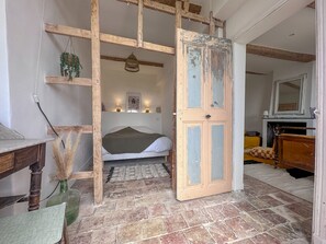 Cozy retreat with a rustic charm, featuring a bed, bedside table, and fireplace.