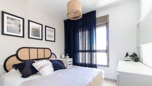 Une chambre à coucher avec un lit, une table de chevet et une fenêtre avec des rideaux.