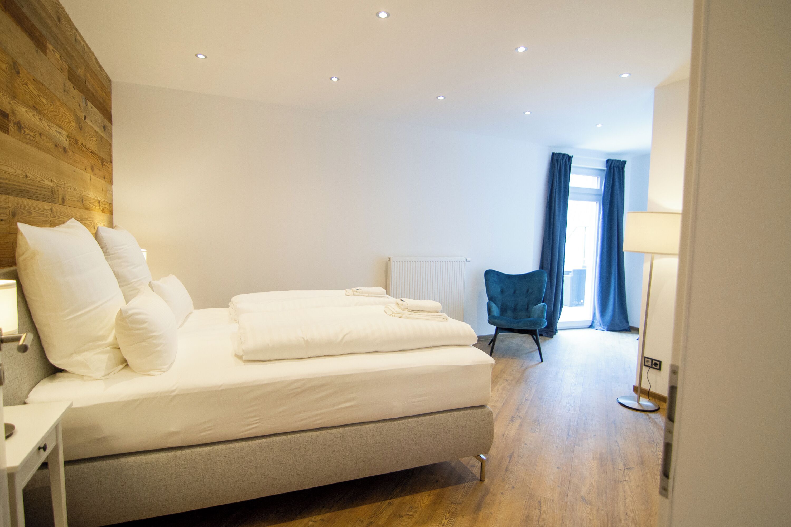 Un dormitorio moderno con cama, mesita de noche y una silla.