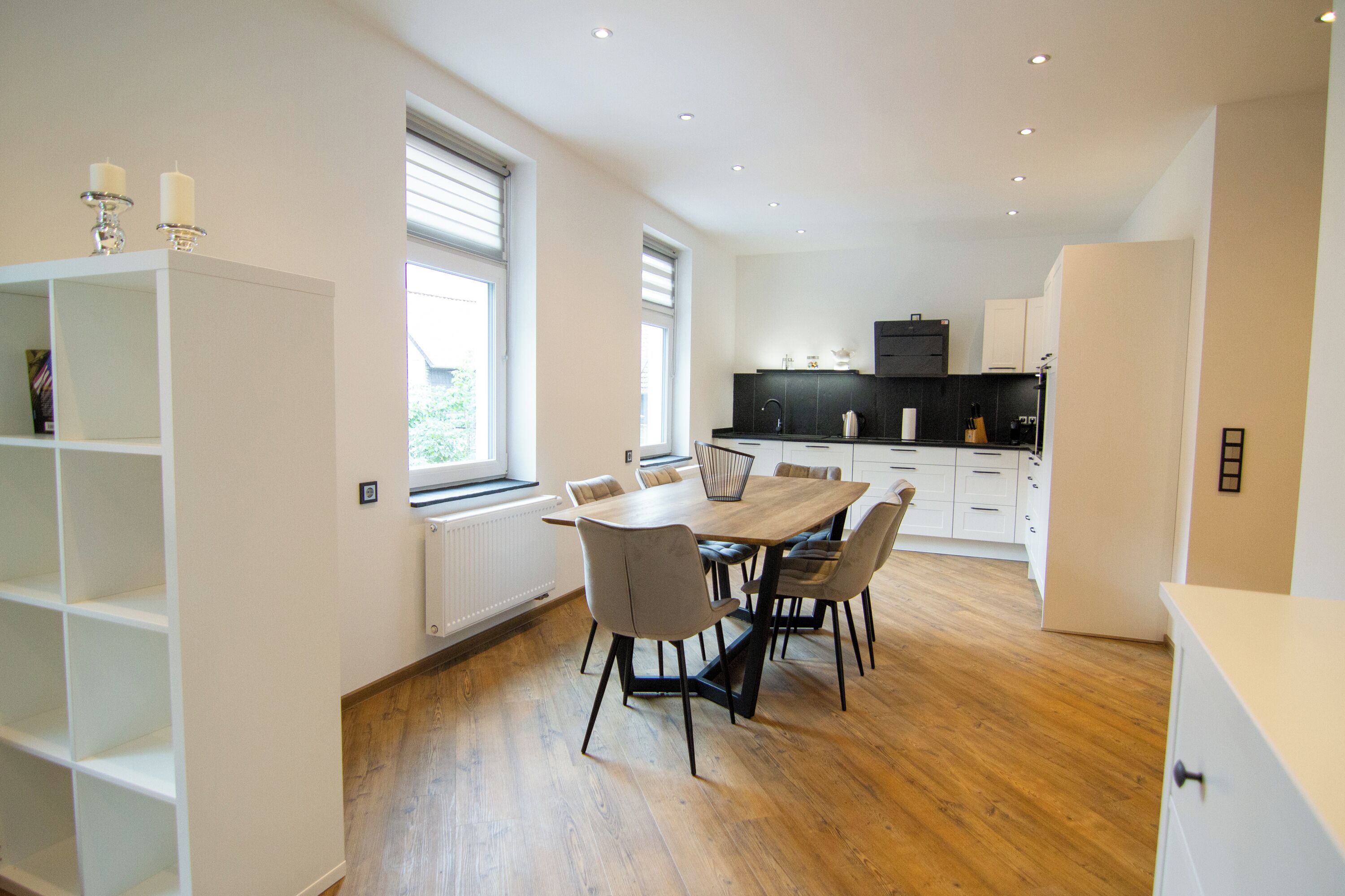 Una cocina moderna con una mesa de comedor, sillas y electrodomésticos integrados.