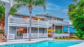 A two-story building with a swimming pool in front. - Florida Life on the water with game room, heated pool, kayaks +
Pet friendly!! (Palm Harbor)