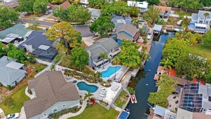 A residential area with houses, a swimming pool, and a canal. - Florida Life on the water with game room, heated pool, kayaks +
Pet friendly!! (Palm Harbor)