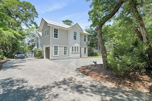 A two-story house with a paved driveway and a well-maintained lawn.