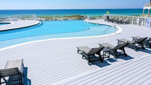 Un espace piscine avec des chaises longues et vue sur l’océan.