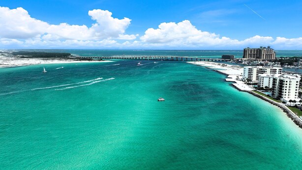 Un hôtel situé sur la côte, doté d’un port de plaisance, d’une eau turquoise cristalline et d’un pont en arrière-plan.