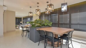 A modern dining area with a wooden table, black chairs, and hanging pendant lights. - Safety and comfort: 2 beds, up to 3 people. New (Campos Elíseos São Paulo)