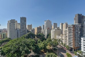 Stadsgezicht met hoge gebouwen, een heldere lucht en een park met bomen.