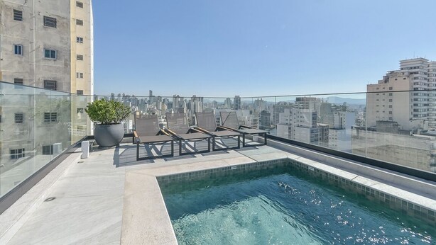 A rooftop pool with lounge chairs and a potted plant, overlooking a cityscape. - Safety and comfort: 2 beds, up to 3 people. New (Campos Elíseos São Paulo)