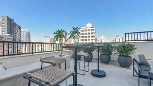 A rooftop terrace with seating, potted plants, and a city skyline view. - Safety and comfort: 2 beds, up to 3 people. New (Campos Elíseos São Paulo)